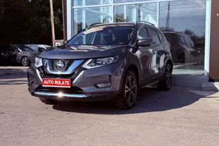 SUV Nissan X-Trail rulat, cu plăcuța „Auto rulate”, parcat în fața unui showroom auto