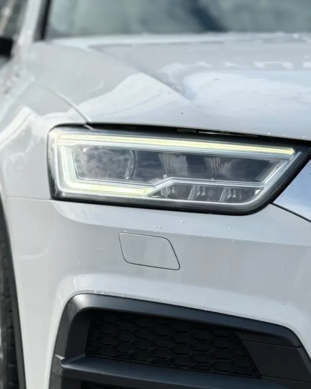 Detaliu far LED al unei mașini albe din showroomul CarShift